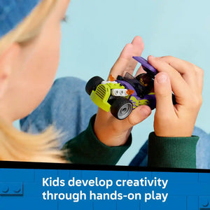 Child's hands holding a bright lime-green and black LEGO hot rod car with purple accents against a clear blue sky, demonstrating creative hands-on play with building blocks