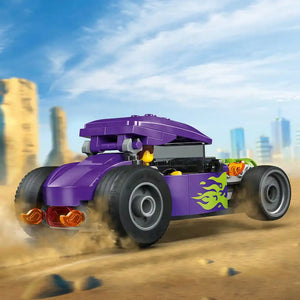 LEGO Hot Rod 60485 purple brick-built race car with yellow flame decals, large black tires, and orange rear lights displayed against a desert landscape with city skyline backdrop