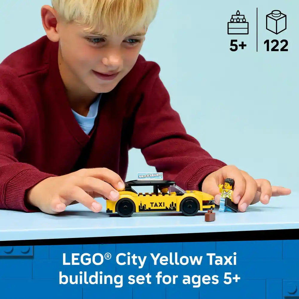 Young child in red sweater playing with LEGO City Yellow Taxi building set featuring yellow taxi car with black details and minifigure, displayed on blue surface with 5+ age rating and 122 pieces indicated