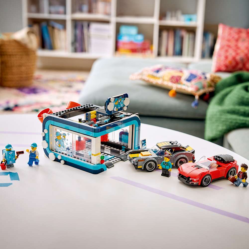 LEGO City Drive-Through Car Wash 60497 set in play, showing the full car wash build with attendant minifigure and both vehicles