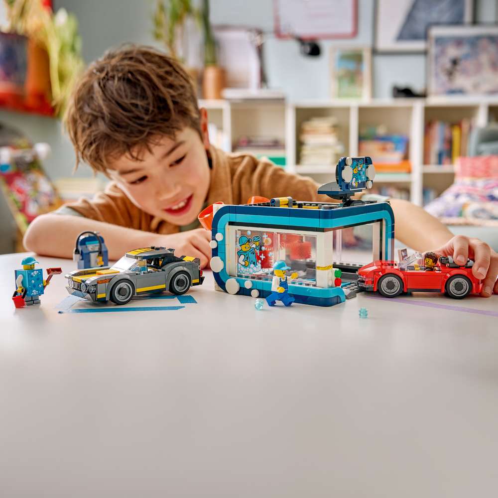 LEGO City Drive-Through Car Wash 60497 child playing with the assembled set, driving a toy car through the spinning brushes