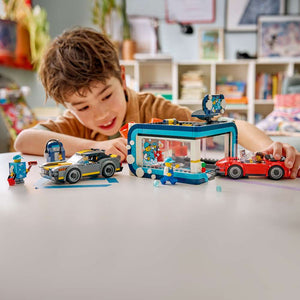 LEGO City Drive-Through Car Wash 60497 child playing with the assembled set, driving a toy car through the spinning brushes