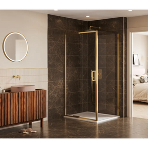 Modern corner shower enclosure with brushed brass frame and clear glass panels featuring an infold door, installed in a luxury bathroom with dark brown marble-effect wall and floor tiles, wooden slatted vanity unit with pink basin, round backlit mirror, and cream walls with vertical ribbed tiles