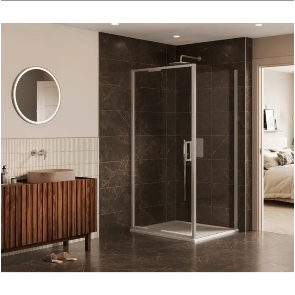 Modern bathroom featuring a chrome-framed 6 Series Sleek infold shower door with clear glass panels installed in a corner configuration, set against dark brown marble-effect wall tiles, white shower tray, complemented by a wooden slatted vanity unit with terracotta basin, round LED backlit mirror, and cream vertical wall tiles