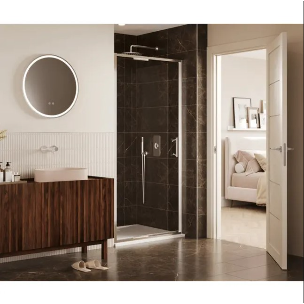 Modern bathroom featuring a sleek chrome-framed infold shower door with clear glass panel, set against dark brown marble-effect wall tiles. The contemporary space includes a wooden vanity unit with ribbed cabinet doors, white vessel sink, round LED-lit mirror, and cream fluted wall tiles. Beige slippers rest on dark polished floor tiles, with an open white door revealing an adjoining bedroom