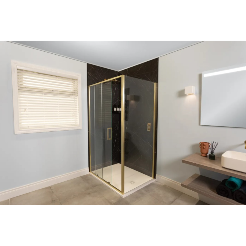 Merlyn 6 Series Sleek sliding shower enclosure with brushed brass frame and dark grey marble-effect panels in modern bathroom with white walls, wooden vanity, and cream venetian blind