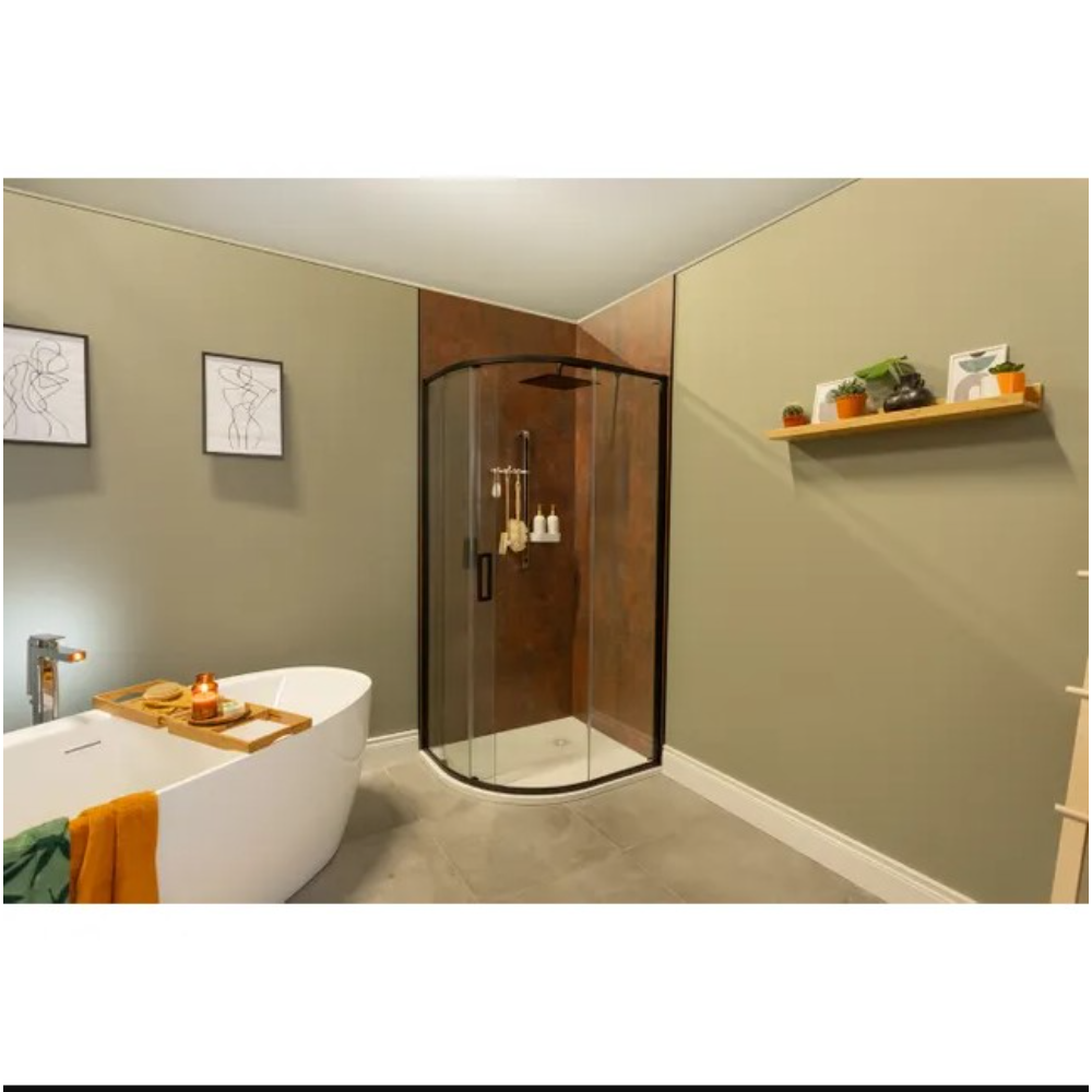 Modern bathroom featuring a curved quadrant shower enclosure with sleek black frame and clear glass panels, rust-toned copper wall panels inside the shower, freestanding white oval bathtub with bamboo bath caddy, sage green walls, grey floor tiles, minimalist line art prints, and wooden floating shelf with decorative plants and ornaments