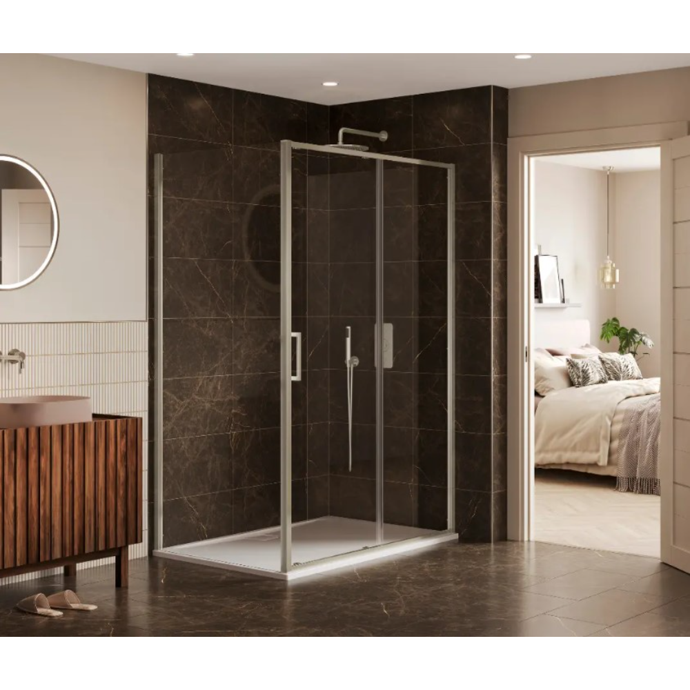 Modern bathroom featuring a Merlyn 6 Series chrome framed sliding shower enclosure with dark marble tiled walls, white base tray and brushed metal handles, positioned in a luxurious ensuite with beige walls, wooden vanity cabinet, circular mirror and view into bedroom beyond