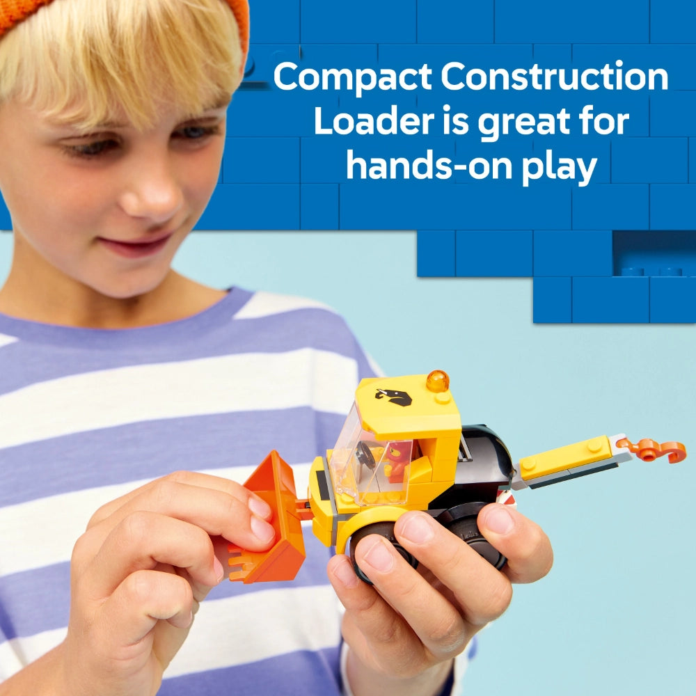 Child wearing striped purple and white shirt playing with yellow and orange LEGO construction loader toy against blue background with text reading Compact Construction Loader is great for hands-on play