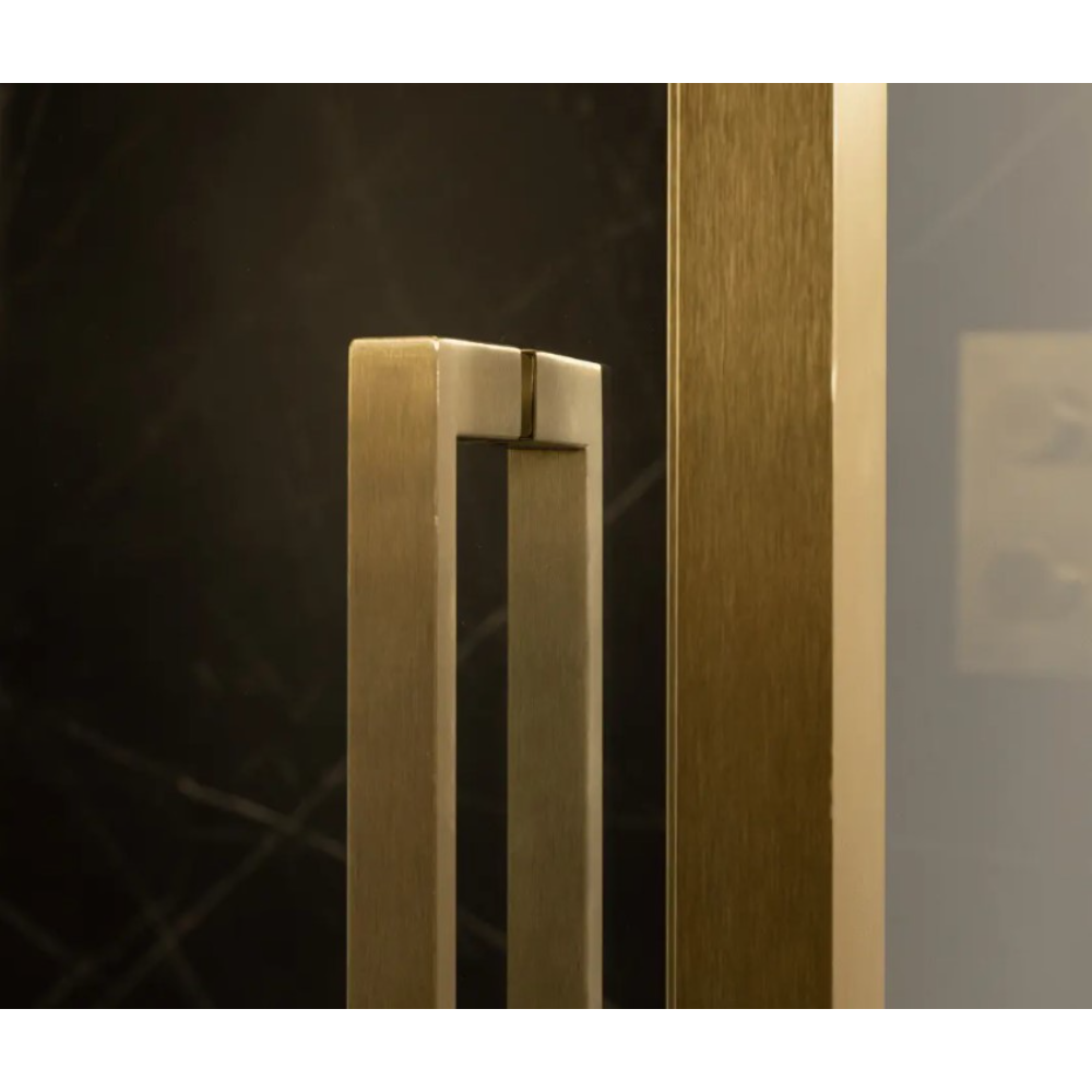 Merlyn 6 Series Sleek brushed brass sliding shower door with handle detail against dark background, showing modern minimalist design and finish