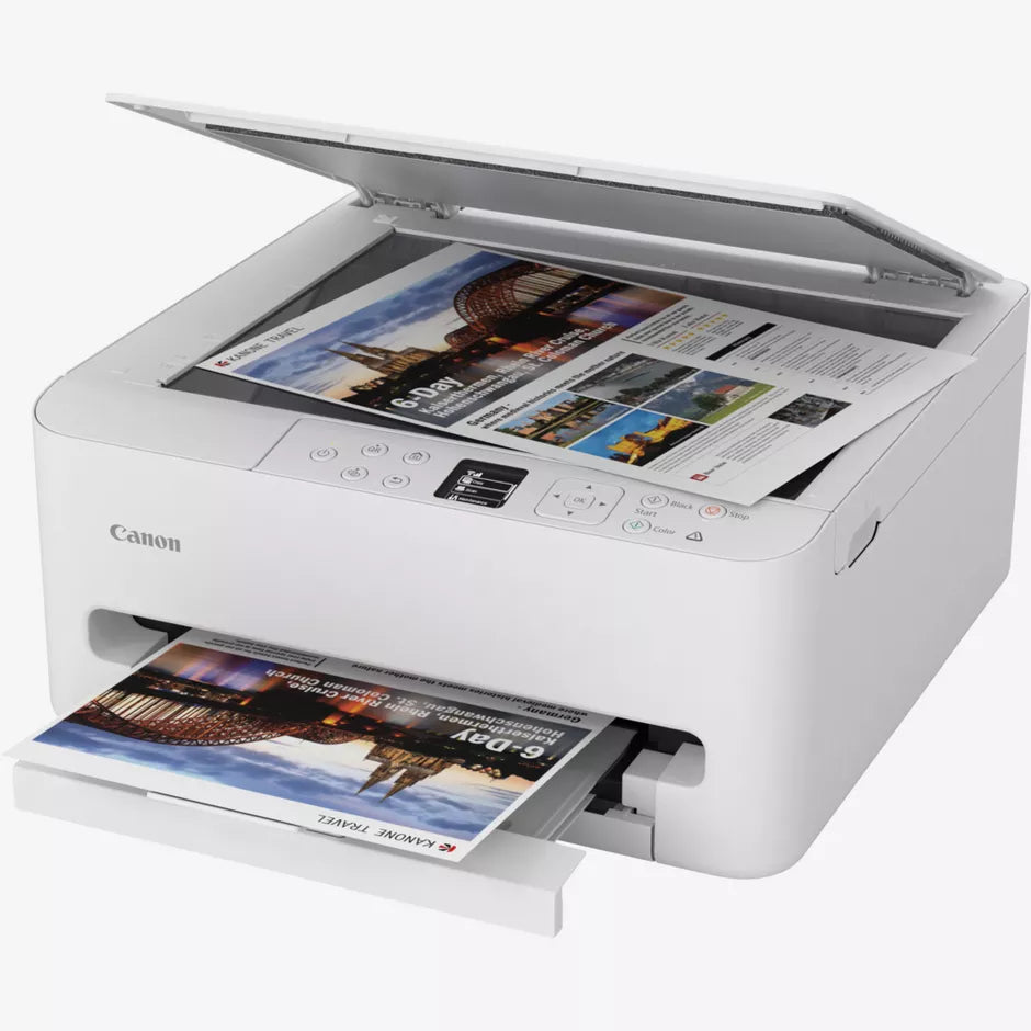 Canon TS6550i white all-in-one wireless inkjet printer with open scanner lid showing colorful travel magazine page being scanned, and printed photo exiting from output tray below