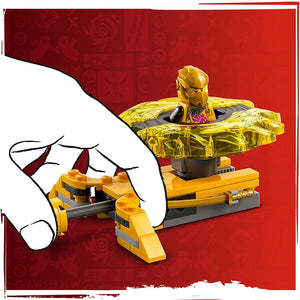 LEGO Ninjago golden dragon spinner set with yellow and black minifigure character on red background, featuring rotating golden dragon wing pieces and yellow base platform