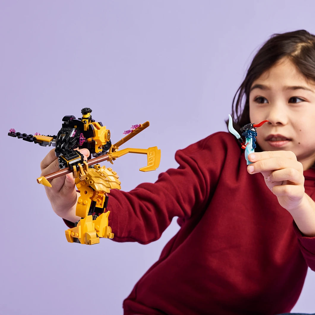 Child in maroon hoodie holding yellow and black LEGO Ninjago Arin's Spinjitzu Battle Mech set against purple background, displaying transforming mech toy with articulated limbs and weapon accessories