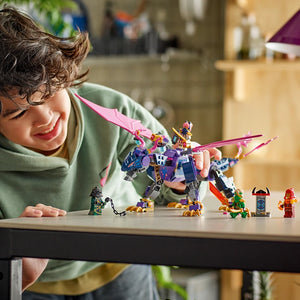 Child in green hoodie playing with LEGO Ninjago Rontu the Master Dragon set 71842, featuring a large purple and blue dragon figure with pink wings, minifigures, and accessories displayed on a white table