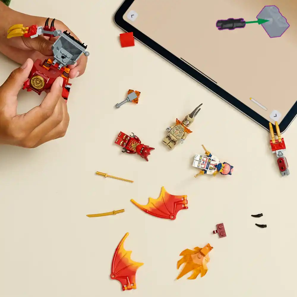 LEGO Ninjago Kai's Dragon Mech Battle Pack 71851 displayed with assembled red mech figure held in hands and disassembled components including golden weapons, orange dragon elements, minifigures, and mechanical pieces arranged on white surface