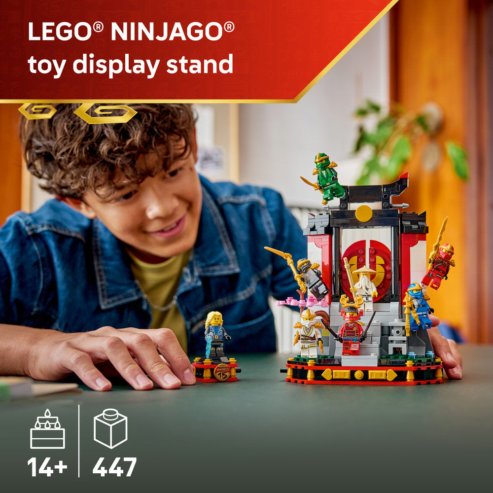 LEGO Ninjago 15th Anniversary display stand featuring multiple minifigures and an ornate red and white temple structure with gold accents, displayed by a smiling child in a blue denim shirt, 447 pieces for ages 14 and up