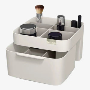 White Joseph Joseph Viva cosmetic makeup organizer with drawer featuring multiple compartments holding brushes, powders, lipsticks and beauty products, modern minimalist design with chrome and black accents