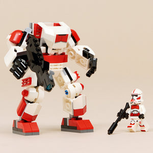 LEGO Clone Shock Trooper Mech 75448 set featuring red white and black buildable mech robot with articulated limbs, twin black weapons, minifigure clone trooper with blaster rifle, and tan base platform against neutral background