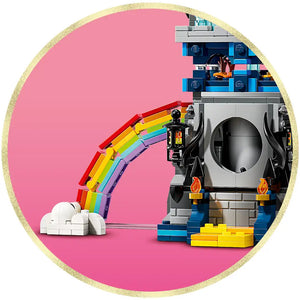 LEGO Wicked Emerald City and Kiamo Ko Castle set 75689 featuring a colorful rainbow bridge with white cloud base on the left, connected to a detailed gray castle structure with blue and black elements, orange flames, and yellow bricks on a pink circular background with gold glitter border