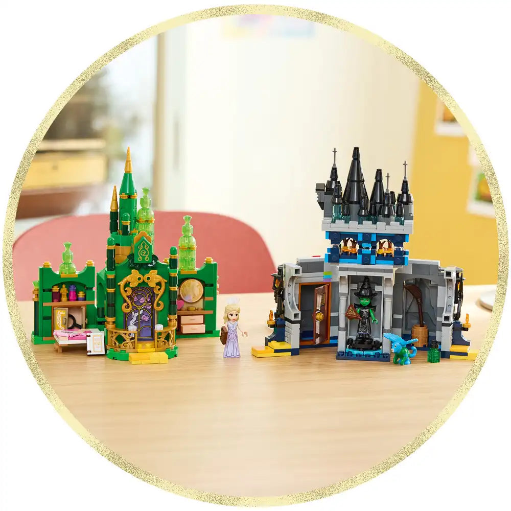 LEGO Wicked Emerald City green castle and Kiamo Ko black tower castle sets displayed on wooden floor, featuring minifigures, colorful brick construction, and detailed architectural elements in gold-framed circular product photo