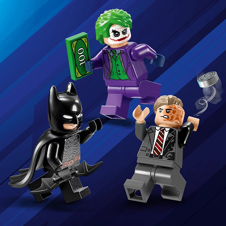 Three LEGO minifigures from The Batman Movie set 76303 displayed against a blue diagonal striped background: Batman in black suit with cape on the left, The Joker in purple suit with green hair holding green money in the center, and Two-Face in gray business suit with scarred face on the right