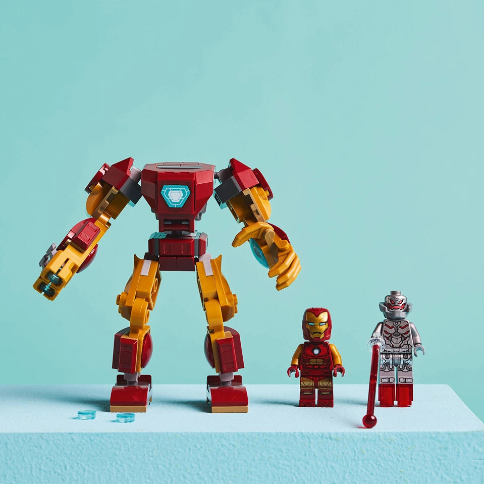 LEGO Iron Man Mech vs Ultron set 76307 featuring a large red and gold armored mech suit with articulated arms and legs, alongside three minifigures including Iron Man and Ultron characters against a light blue background