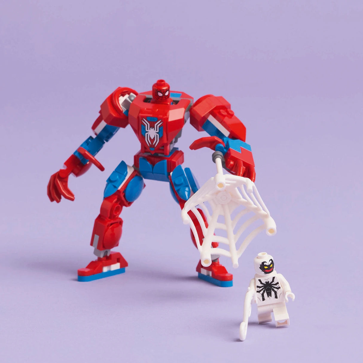 LEGO Spider-Man red and blue mech suit with articulated limbs and spider emblem on chest, displayed next to white LEGO minifigure with black spider design against purple background