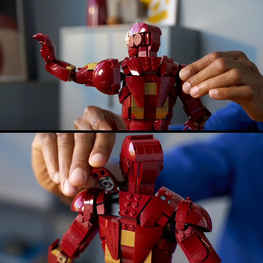 Child's hands displaying a red and gold LEGO Iron Man Mark 3 minifigure in articulated pose against a blurred indoor background, showcasing the buildable armor suit's detailed construction and poseable joints