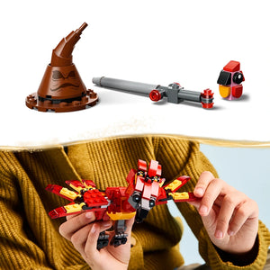 LEGO Fawkes Dumbledore's Phoenix set 76448 showing brown wizard hat with accessories, gray cannon, red and black robot figure, and red and yellow phoenix minifigure being held in child's hands wearing yellow sweater