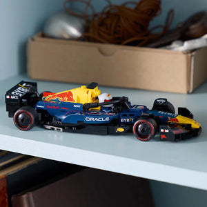 LEGO Oracle Red Bull Racing RB20 F1 race car model displayed on a light blue surface, featuring blue and yellow bodywork with black accents, sponsor logos including Oracle and Bybit, displayed in front of a cardboard storage box against a light blue wall