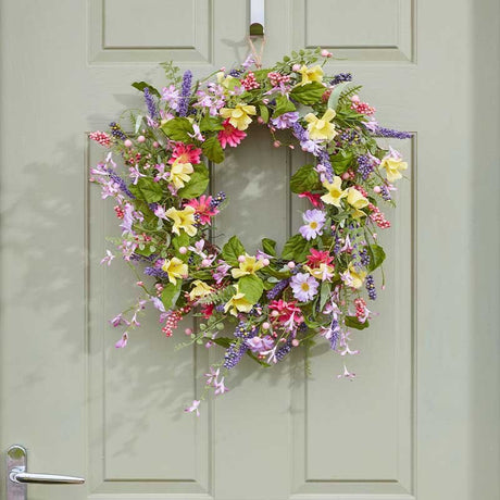 Colorful spring flower wreath hanging on pale green door featuring pink, purple, yellow and red blooms with green foliage and trailing vines, 45cm diameter Smart Garden design