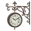 Vintage-style bronze wall-mounted clock with ornate scrollwork bracket, cream face with Roman numerals, and decorative fleur-de-lis finial, Marylebone Station design
