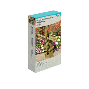 Woodland Extra Large Windmill garden ornament in natural wood finish displayed in product packaging with turquoise top and cream base, shown against brick wall with flowering plants