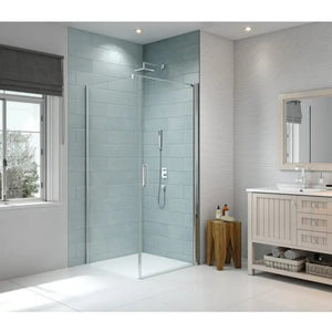 Merlyn 8 Series frameless pivot shower door in chrome with clear glass panels installed in a modern bathroom with light blue subway tile walls, white basin vanity unit and wooden accessories