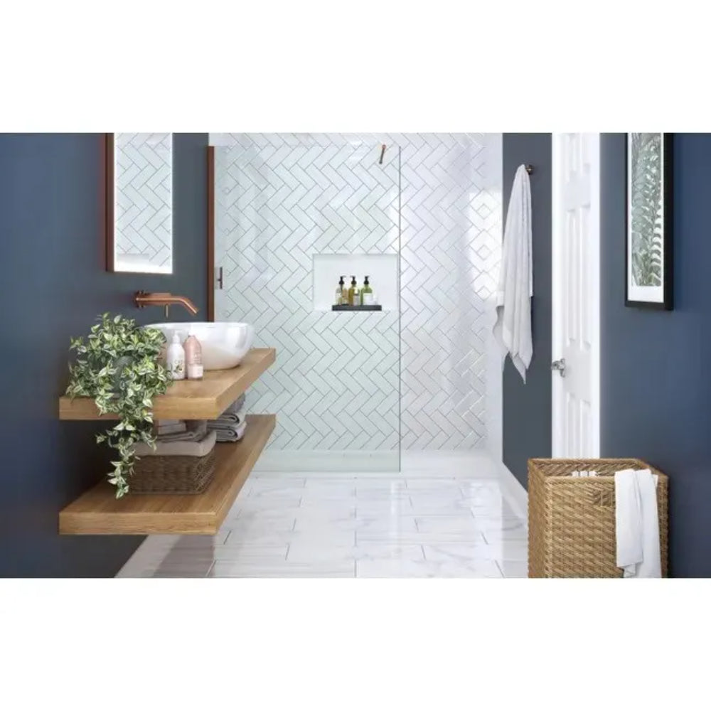 Modern bathroom with Merlyn 8mm glass wetroom panel featuring herringbone tile pattern, wooden floating vanity with white basin, dark blue-grey walls, brushed metal fixtures, and white tile flooring