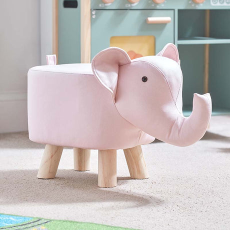 Pink plush elephant-shaped footstool with wooden legs in a modern nursery setting, featuring soft fabric body and decorative ears
