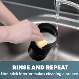 A hand rinsing the black non-stick interior of a Daewoo electric milk frother under running water in a stainless steel sink, demonstrating easy cleaning with text overlay reading "Rinse and Repeat - Non-stick interior makes cleaning a breeze"