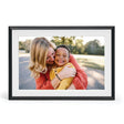 Aura Carver 10.1 inch WiFi digital photo frame with matte black border and white mat displaying a portrait photo of a woman and young child outdoors