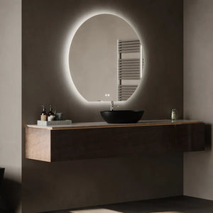 Modern bathroom vanity with oval LED-lit mirror, black ceramic sink, dark wood floating cabinet, chrome towel rail, and warm white wall lighting in contemporary minimalist style