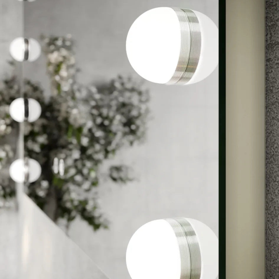 Modern LED bathroom mirror 800x700mm with integrated white circular lights and brushed silver trim, mounted on white wall above vanity with decorative white flowers and green foliage