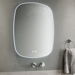 Modern Aqualla Trace LED bathroom mirror with rounded rectangular frame in white, mounted on grey textured wall above white subway tiles, featuring integrated LED lights and chrome wall-mounted faucet with towel ring