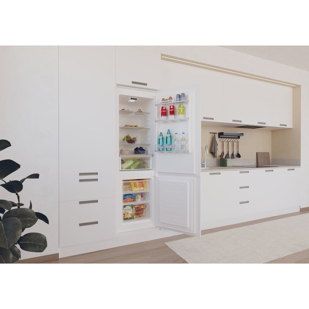 Modern kitchen with a white refrigerator door open, revealing food items.