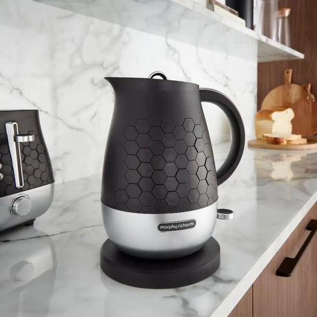 Morphy Richards Cassini 1.7 litre jug kettle in moonless night black and silver on a marble kitchen countertop with hexagonal texture detailing and matching toaster in background