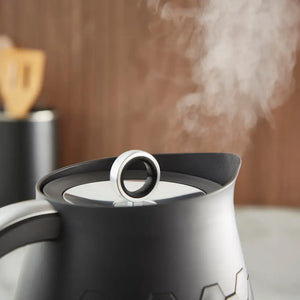 Morphy Richards Cassini 1.7 litre jug kettle in moonless night black and white with steam rising from spout, showing modern design with chrome accents and heat-resistant handle on warm neutral background