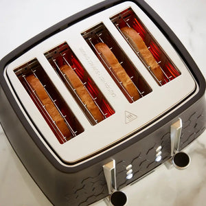 Morphy Richards Cassini 4 slice toaster in moonless night black with cream and red accent heating elements visible through transparent slots, featuring chrome handles and control buttons on a marble surface