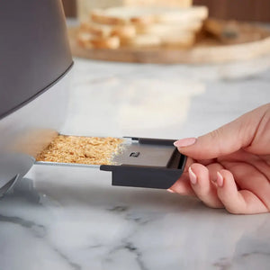 Hand inserting a slice of whole wheat bread into a Morphy Richards Cassini 4 slice toaster with black and white design on a marble countertop