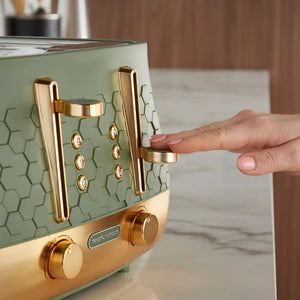 Person demonstrating the lever mechanism on a Morphy Richards Cassini 4-slice toaster with sage green hexagonal tile pattern body, rose gold metal accents, and control dials on the base