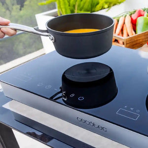 Curry pan on black double Induction Hob on a white background