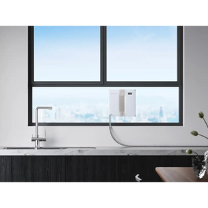 Ecovacs Winbot Mini beige robot window vacuum displayed on a modern kitchen windowsill with stainless steel tap, overlooking a city skyline through black-framed windows