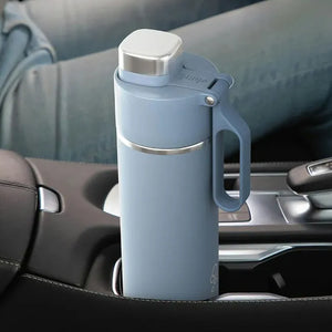 Ninja Thirsti 530ml insulated travel bottle in tropical blue with stainless steel cap and handle, positioned in a car cup holder